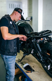 Man repairing motorcycle in garage