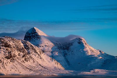 Scenic view of snowcapped mountain against blue sky