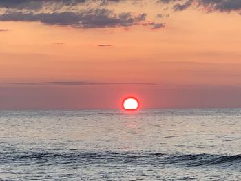 Scenic view of sea against romantic sky at sunset