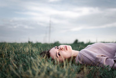 Portrait of woman lying on field