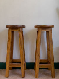 High angle view of wooden chair on table against wall at home