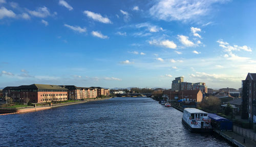 River amidst buildings in city against sky