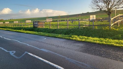 Road amidst field against sky