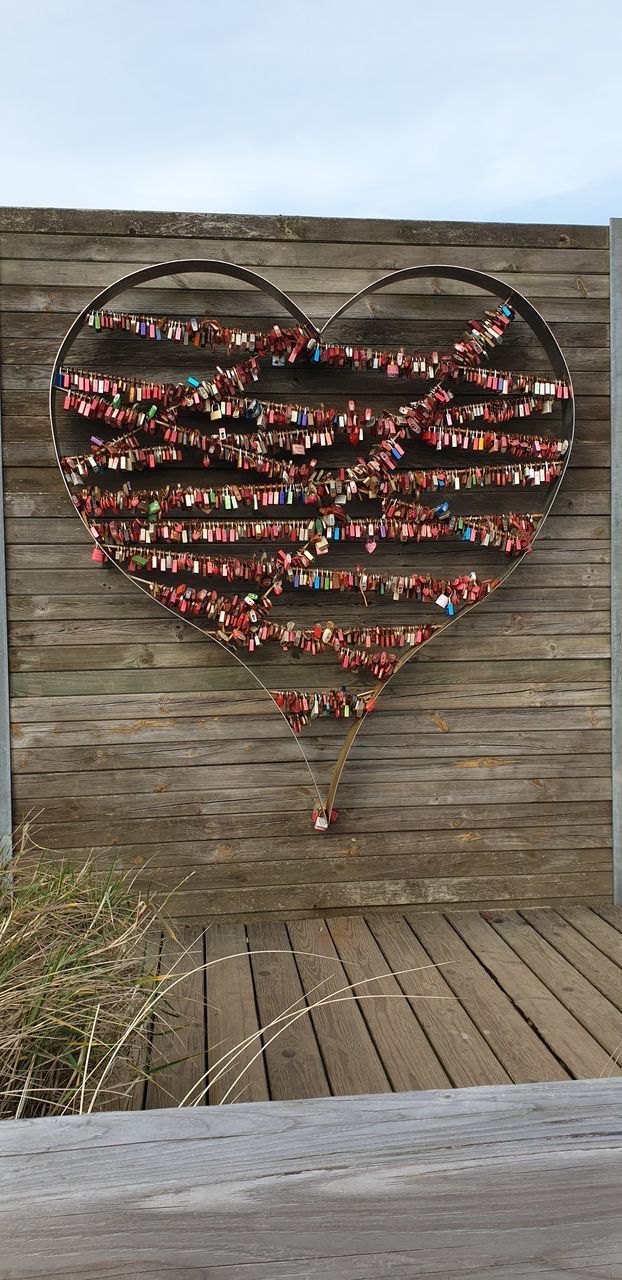 VIEW OF HEART SHAPE DECORATION ON WOODEN RAILING