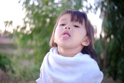 Portrait of cute girl sticking out tongue while standing outdoors