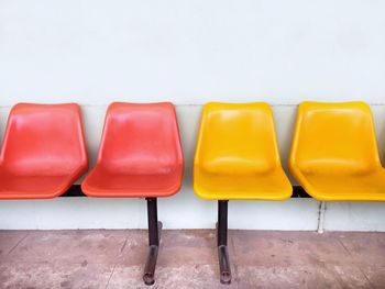 Close-up of empty chairs against wall