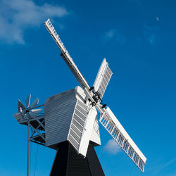 Low angle view of traditional windmill against blue sky