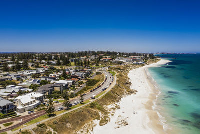 High angle view of buildings by sea against blue sky