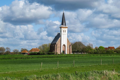 Built structure on field against sky