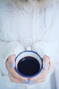 Midsection of woman holding coffee cup