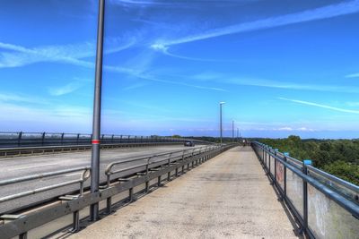 Bridge over road against blue sky