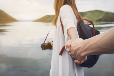 Midsection of woman holding boat in lake