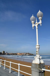 Lighting equipment by beach against sky