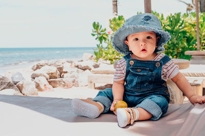 Full length of cute baby sitting on beach