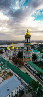 High angle view of city buildings against cloudy sky