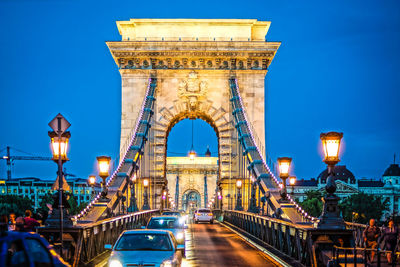 Illuminated bridge against sky at night