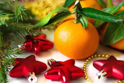Close-up of christmas decoration and orange fruit on table