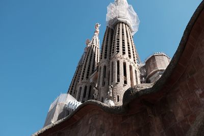 Low angle view of sagrada familia with scaffolding against clear sky