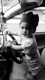 Portrait of cute boy sitting in car