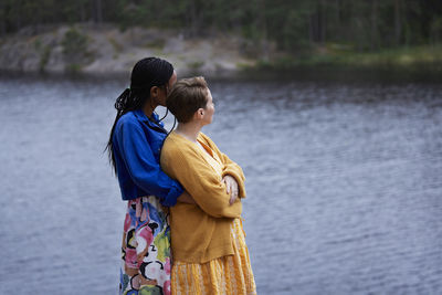 Female couple hugging by river