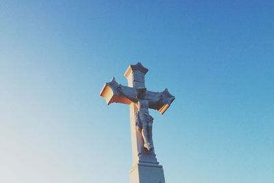 Low angle view of jesus christ on cross against clear sky