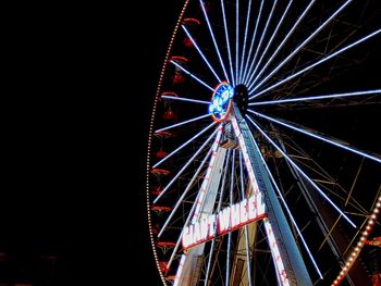 Low angle view of illuminated ferris wheel against sky at night