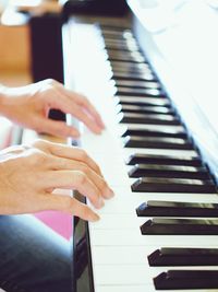 Cropped hands of person playing piano