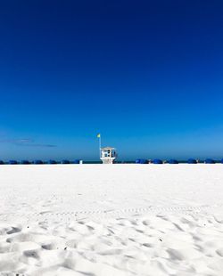 Scenic view of beach against clear blue sky