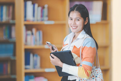 Portrait of smiling young woman reading book