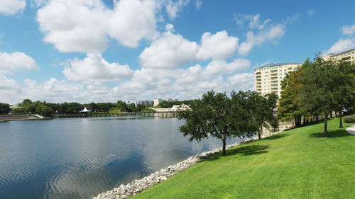 Scenic view of river by buildings against sky