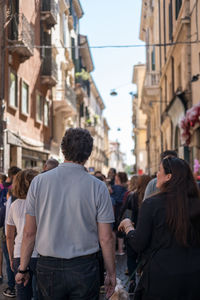 Rear view of people walking on street in city