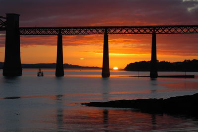 Bridge over river at sunset