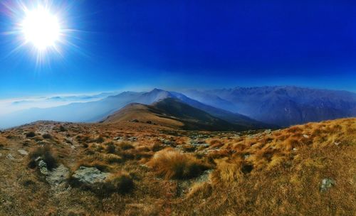 Scenic view of mountains against blue sky