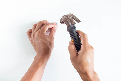 Close-up of hand punching nail in wall