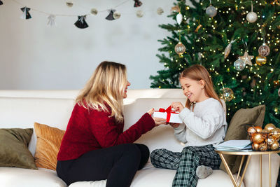 Mother giving gift do daughter at home