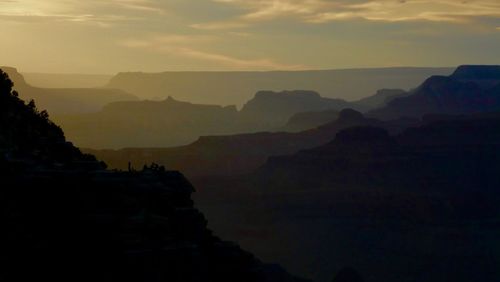 Scenic view of silhouette mountains against sky at sunset