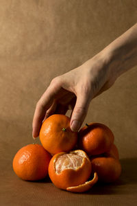 Cropped hand holding orange fruit