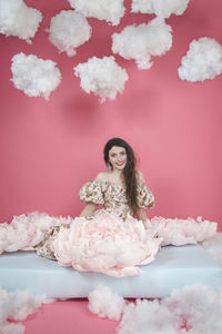 Portrait of young woman with pink flower petals