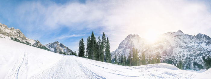 Panoramic view of snow covered landscape against sky