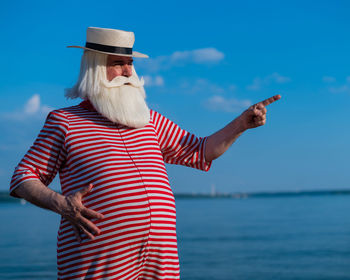 Midsection of man standing by sea against sky