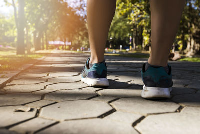 Low section of woman walking on street