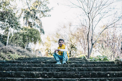 Portrait of boy sitting on staircase