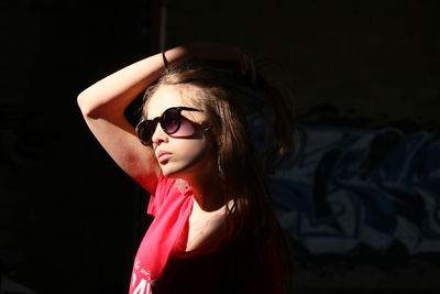 Sunlight falling on girl wearing sunglasses at home