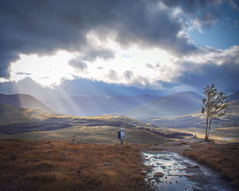 Man standing on landscape against sky