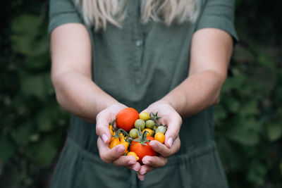 Midsection of woman holding strawberries