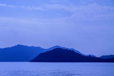 Scenic view of sea and mountains against sky