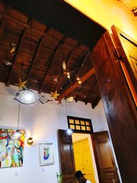 Low angle view of illuminated pendant light hanging on ceiling in building