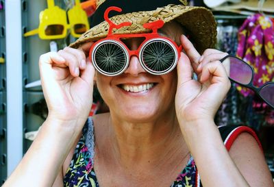 Mid adult woman looking through funky sunglasses