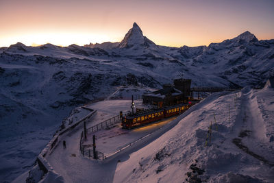 Scenic view of snowcapped mountains against sky during sunset