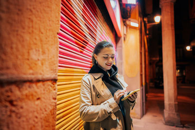 Young woman using mobile phone at night